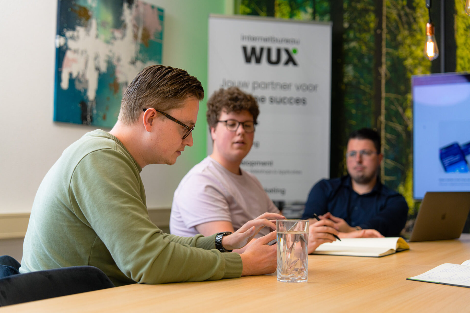 Drie werkende mannen aan het werk zittend achter een tafel