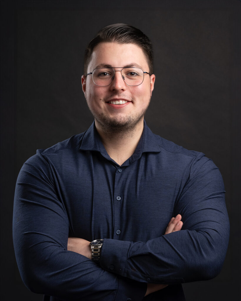 Lachende man met bril op voor zwarte achtergrond, portretfoto