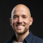 Kale man met stoppelbaard lachend voor zwart achtergrond