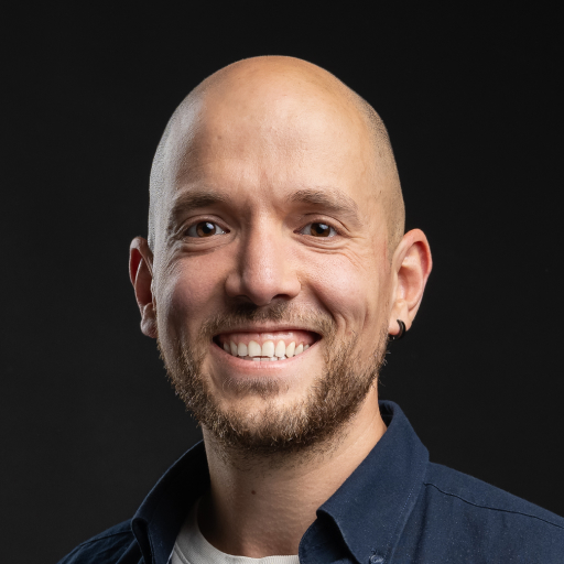 Kale man met stoppelbaard lachend voor zwart achtergrond