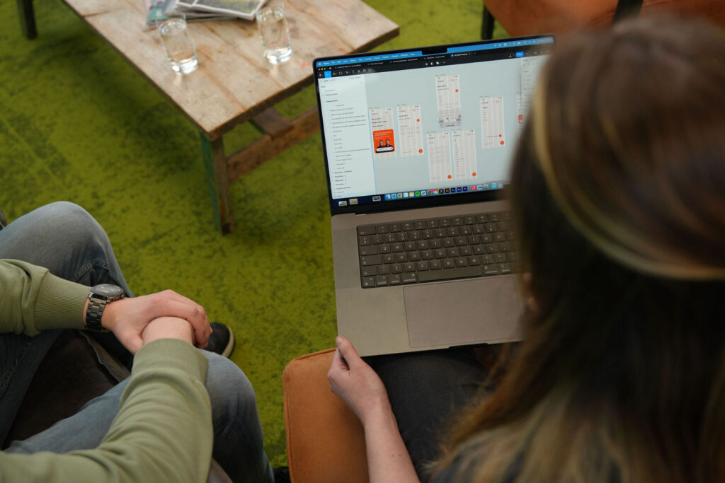 Beeld van laptop waarbij het achterhoofd van een vrouw te zien is